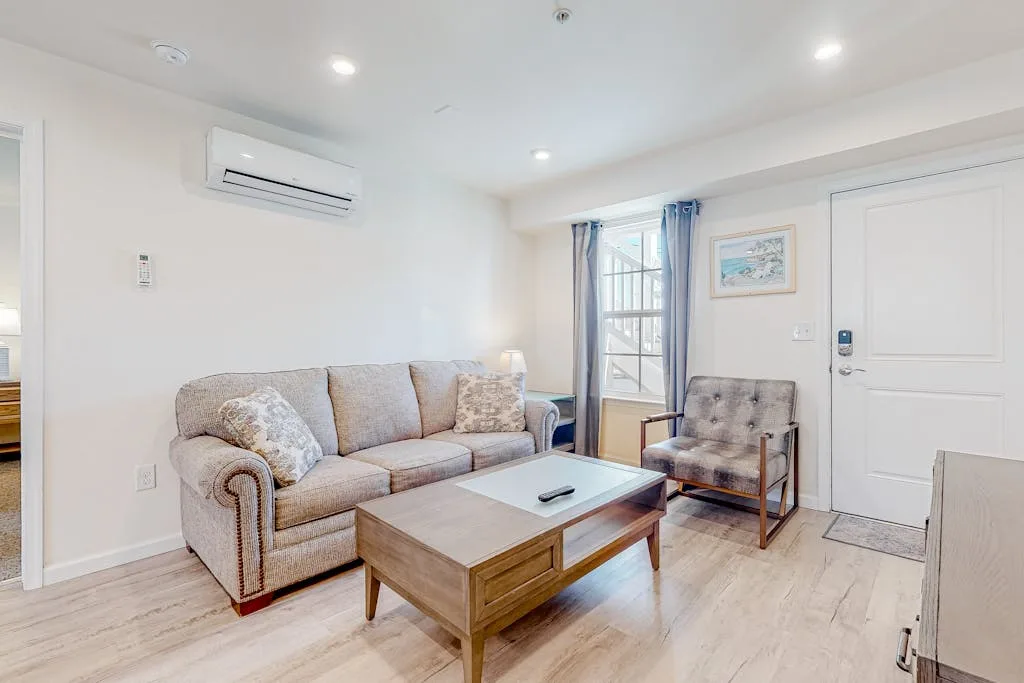 Una sala de estar luminosa con sofá, sillón y mesa de centro.