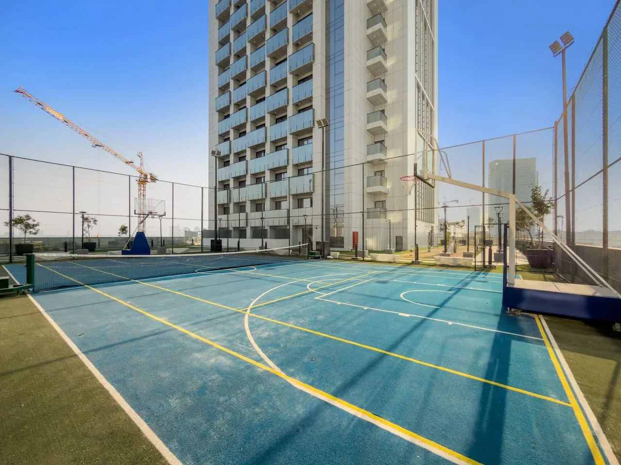 An outdoor sports court with painted lines beside a tall building.