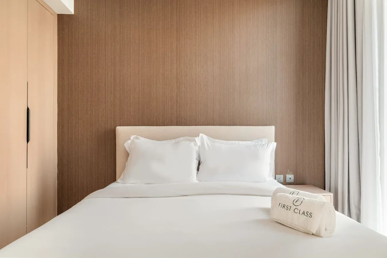 A bedroom with a neatly made bed and white pillows.