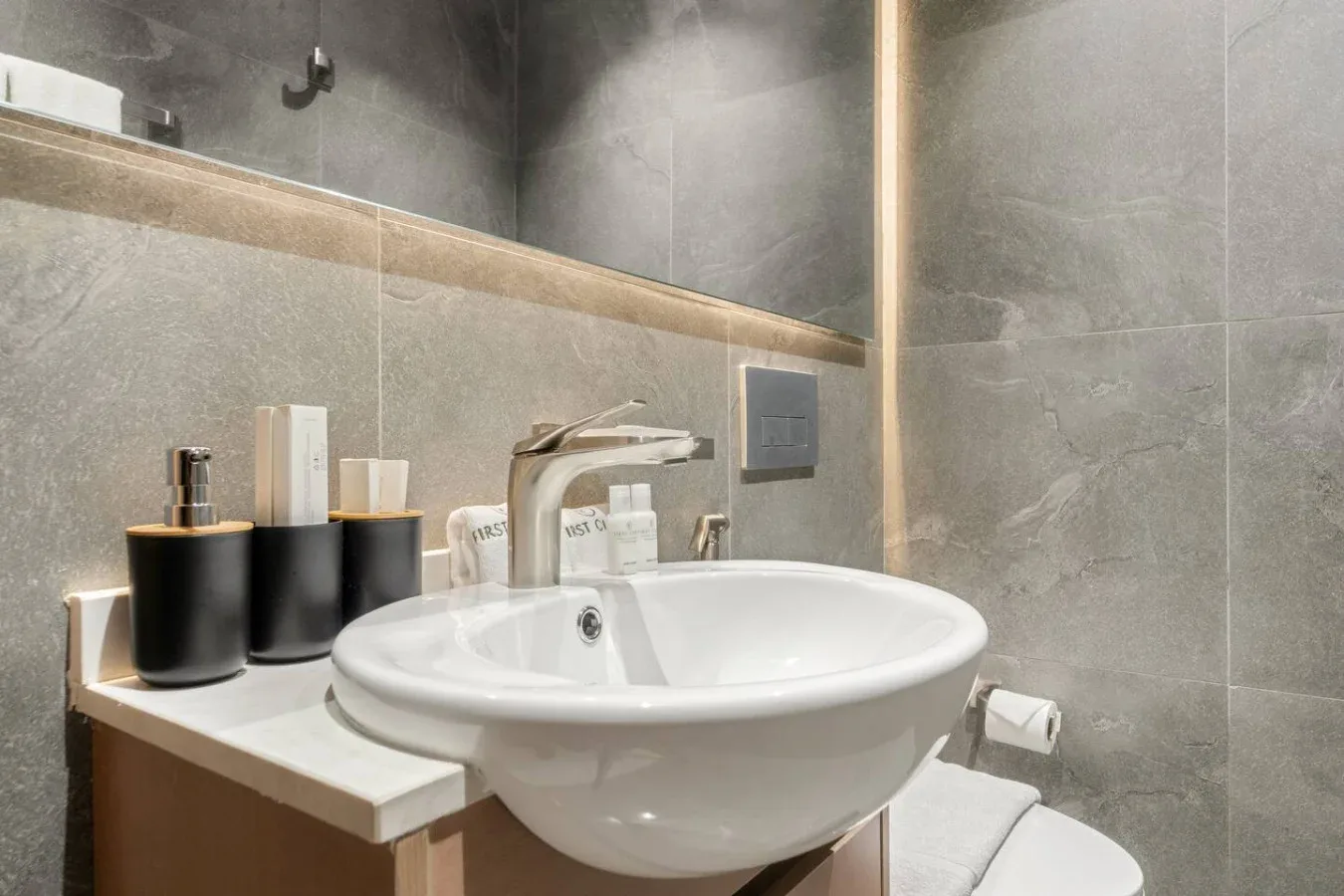 A bathroom sink with a faucet and toiletries on the counter.