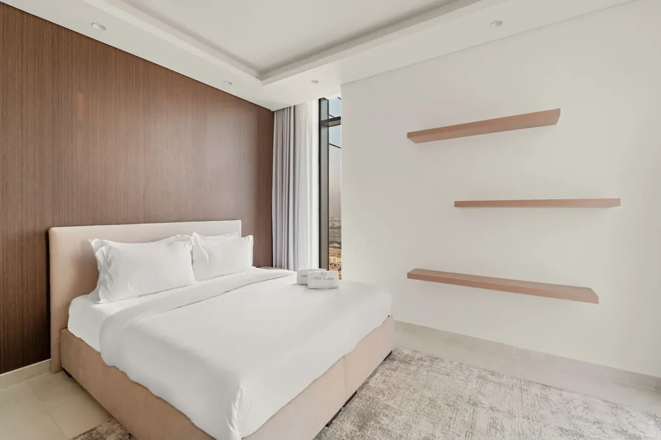 Bedroom with a neatly made bed and floating wall shelves.