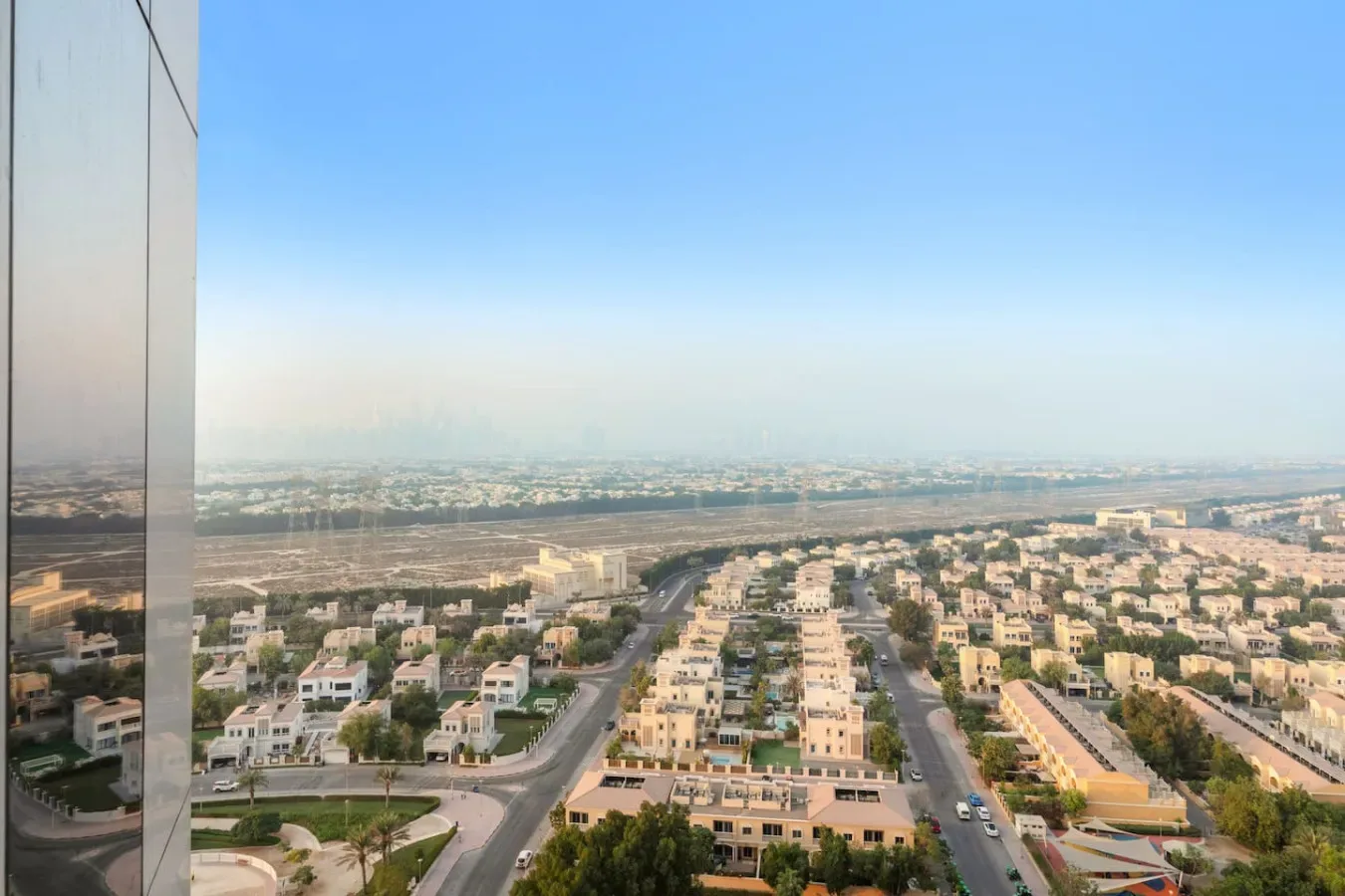 Un amplio paisaje urbano muestra hileras de edificios bajos bajo un cielo despejado.