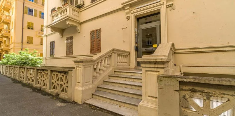 A building entrance with broad stone steps and a decorative low wall.