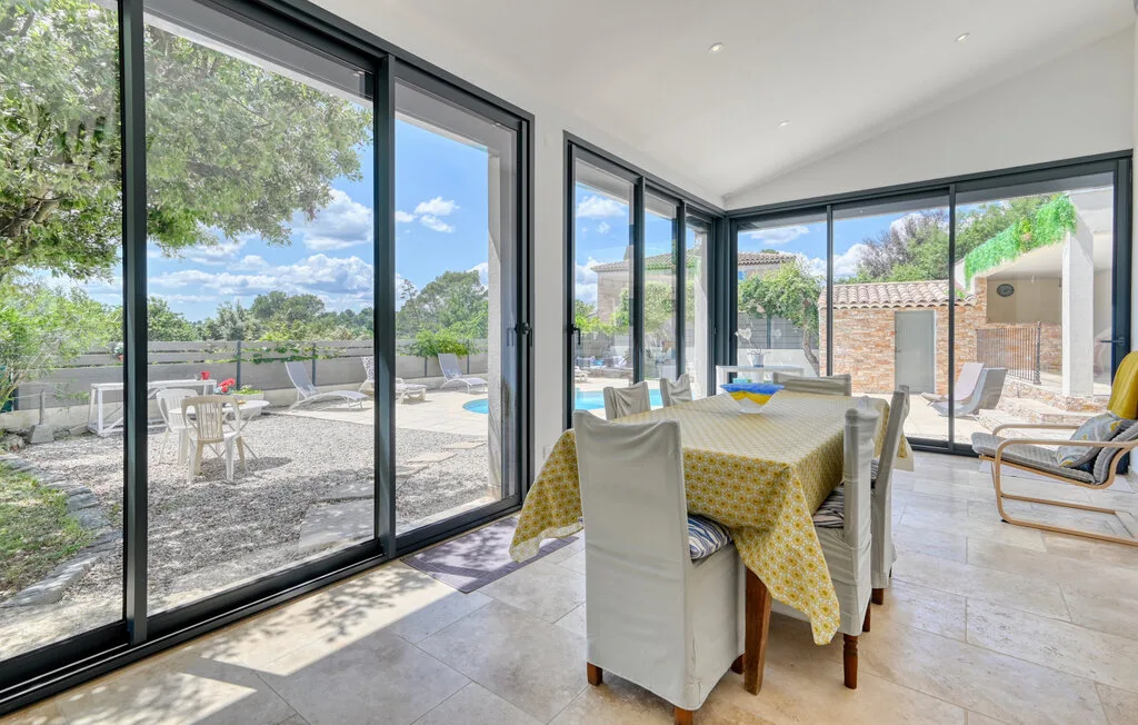 A bright dining area opens through large glass doors onto a sunny patio.
