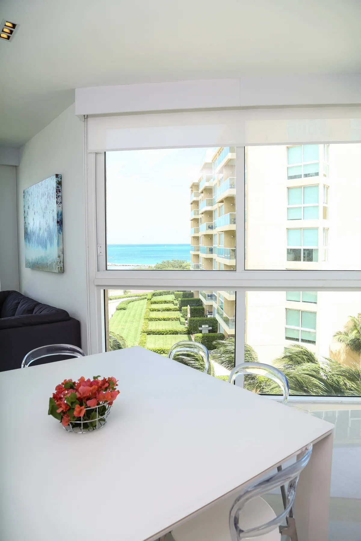 Your bright dining space opens to stunning ocean views through floor-to-ceiling windows—perfect for savoring meals with sparkling turquoise waters as your backdrop.