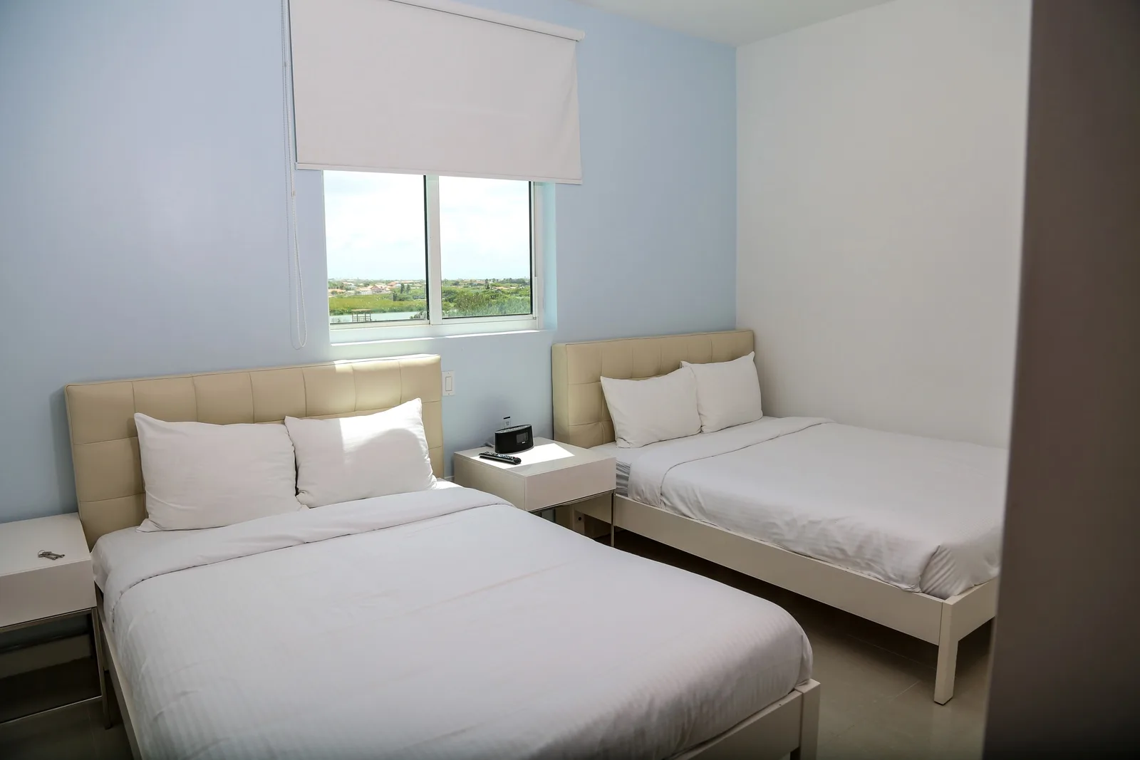 Fresh, light-filled bedroom with crisp linens and plush beds to help you unwind after exploring. The window offers peaceful views to wake up to.