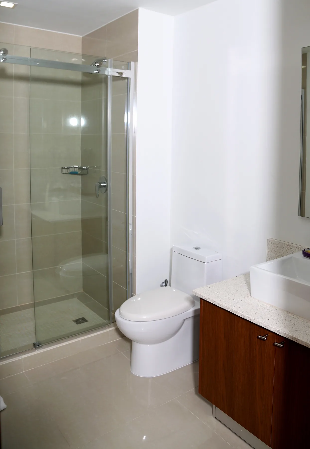 Refresh in your private bathroom with sleek glass shower, modern vanity, and calming neutral tones that make every morning feel like a retreat.