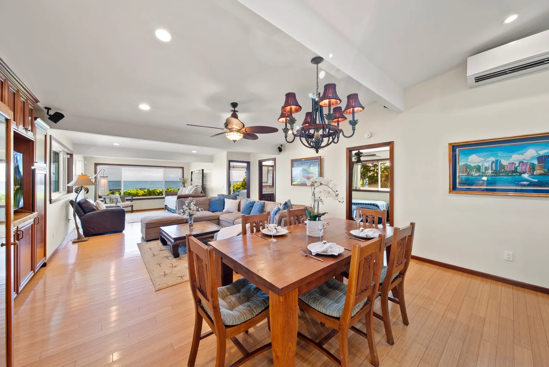 Una zona abierta de comedor y estar cuenta con una mesa de madera y asientos.