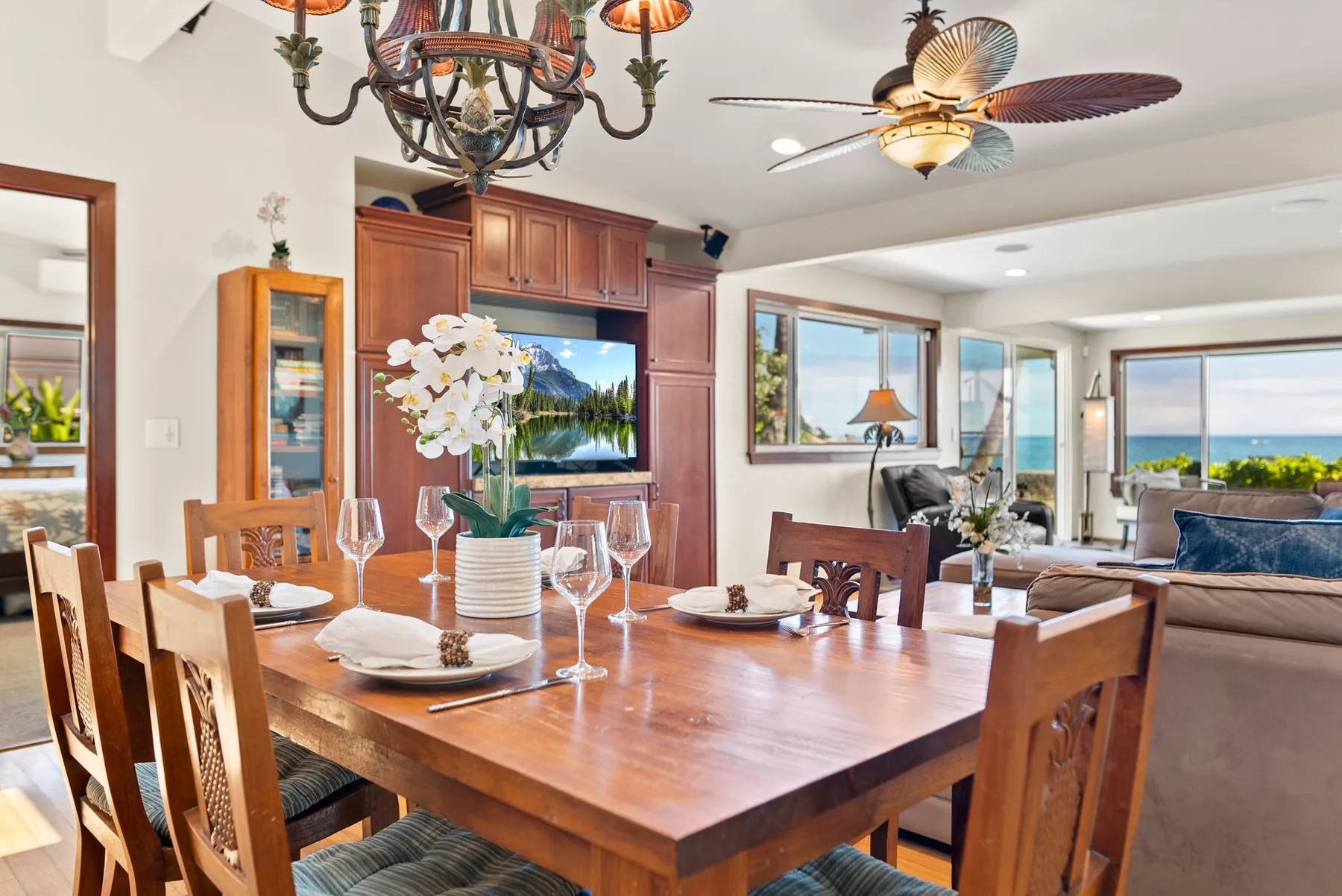 Comedor con una mesa de madera y grandes ventanas con vistas al agua.