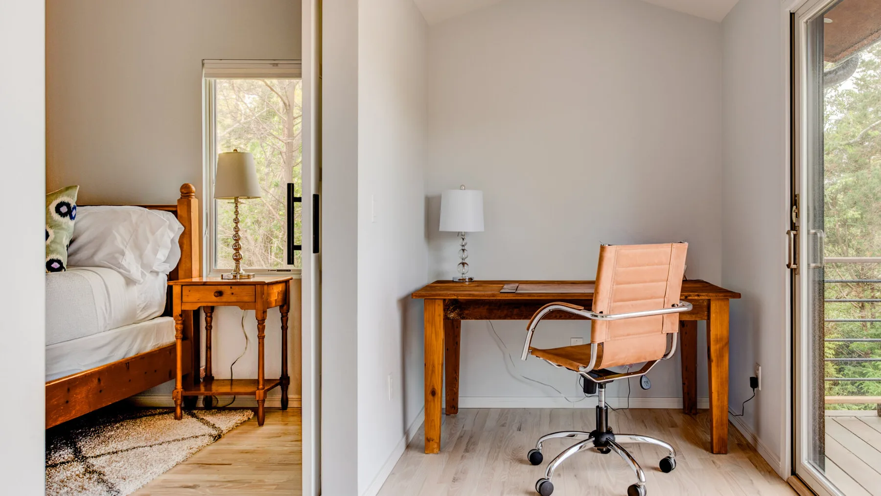A bedroom with a wooden desk and rolling chair beside a bed.