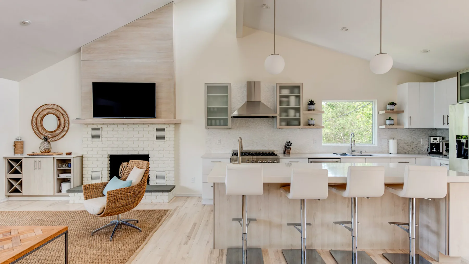 An open-plan kitchen and living area with a breakfast counter and fireplace.