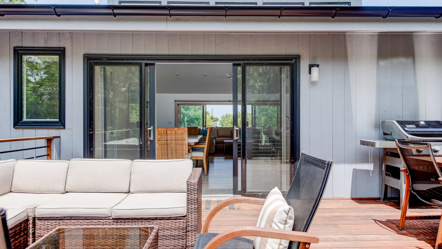 An outdoor patio with seating and wide glass doors opening to an interior dining area.