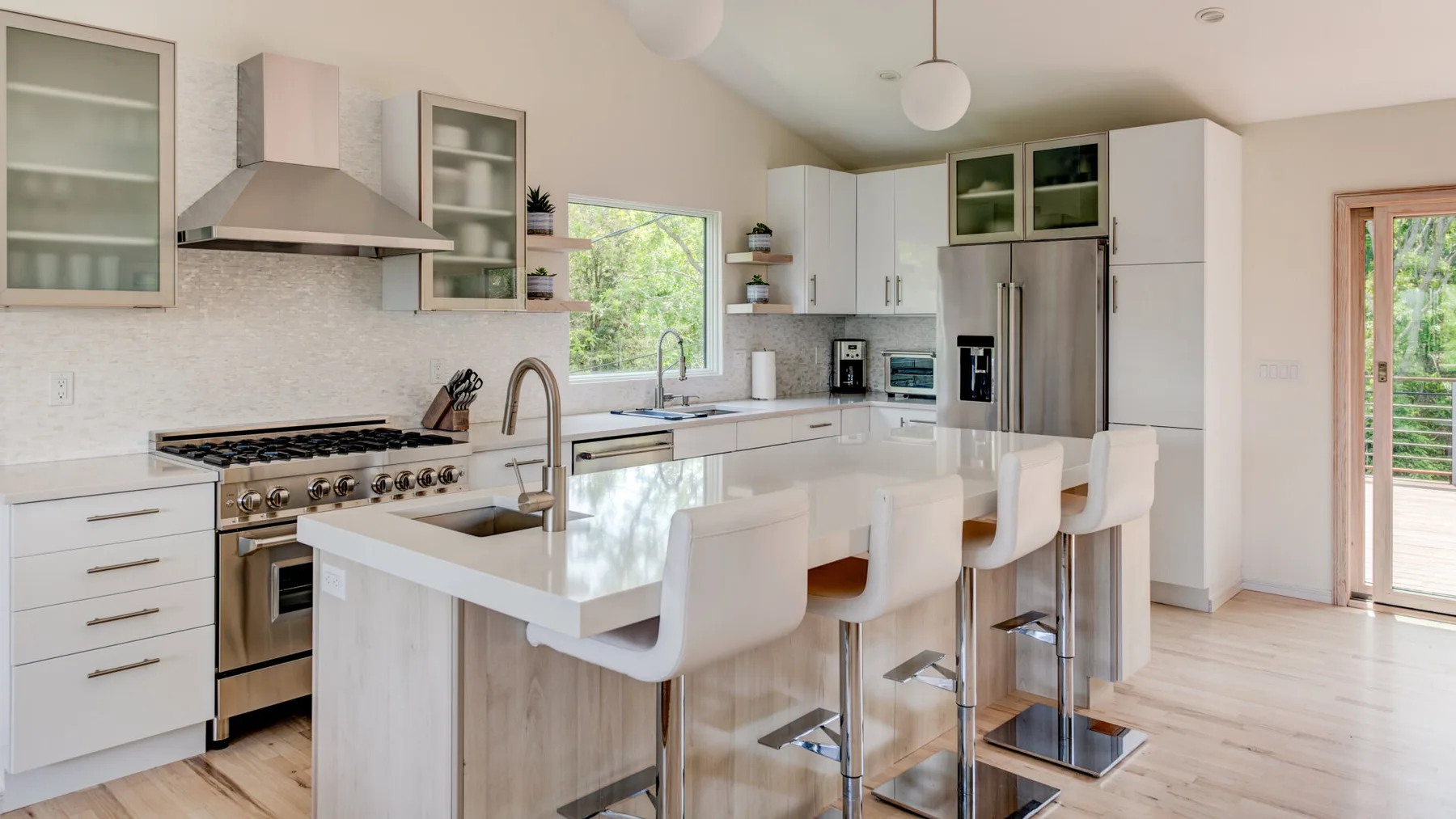 A bright kitchen with a central island and white seating.