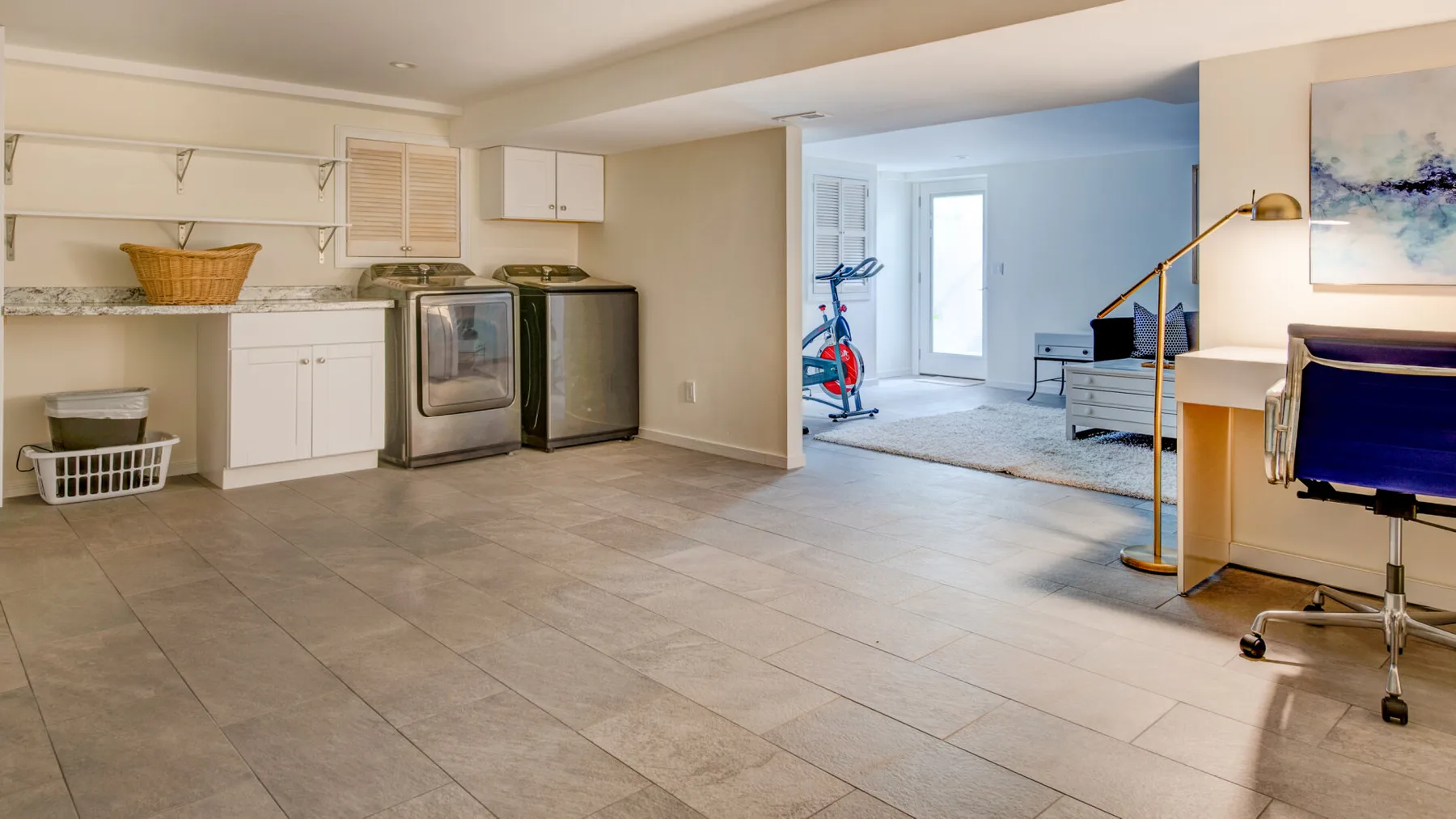 A finished basement combines a laundry area with an open living space.