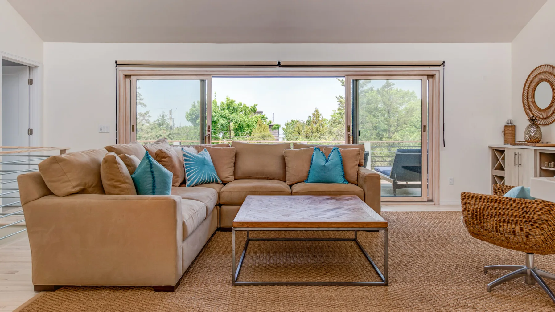 A living room with sectional seating and a coffee table beside large windows.