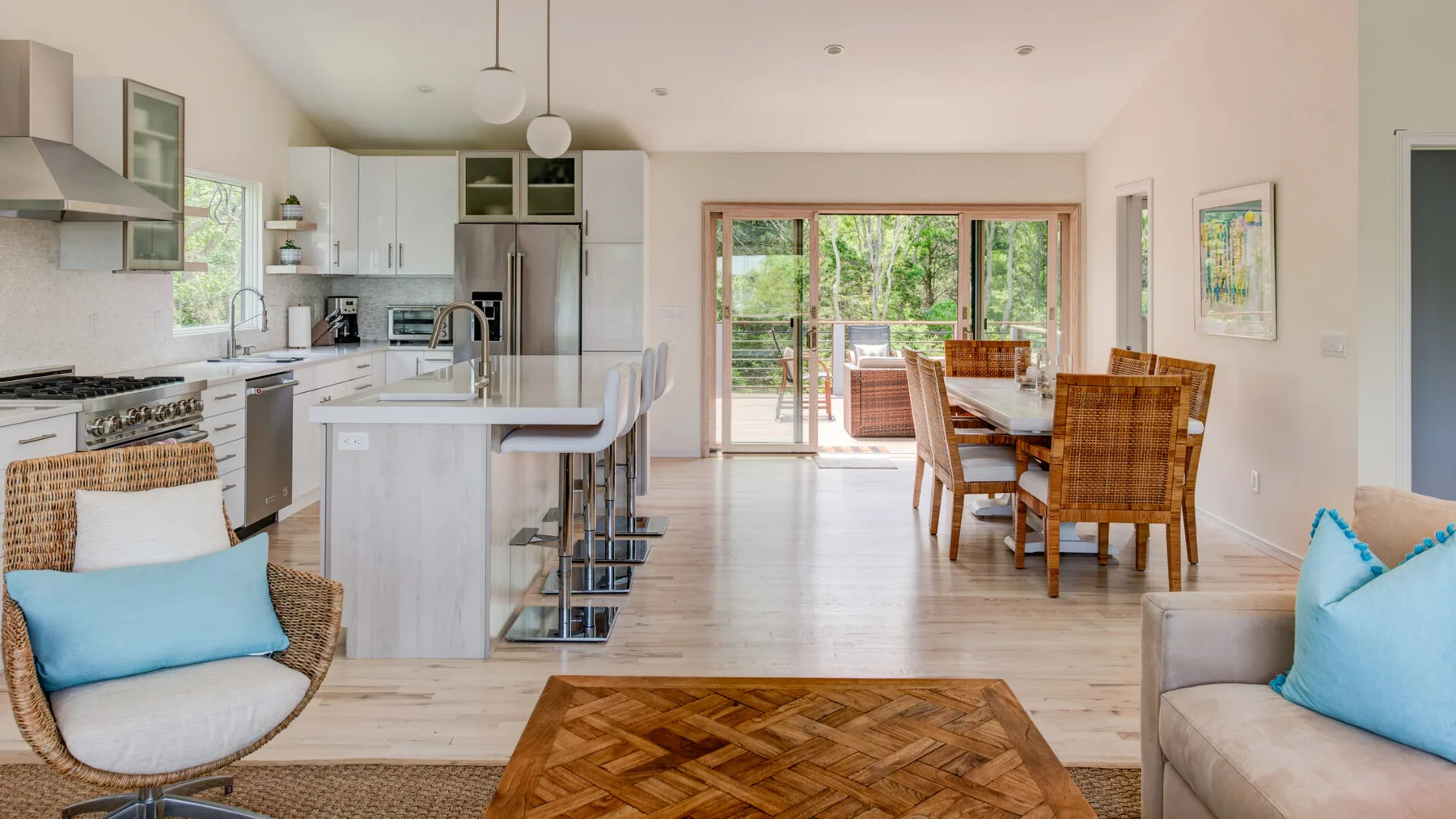 An open kitchen and dining area leads to a bright living space with garden views.