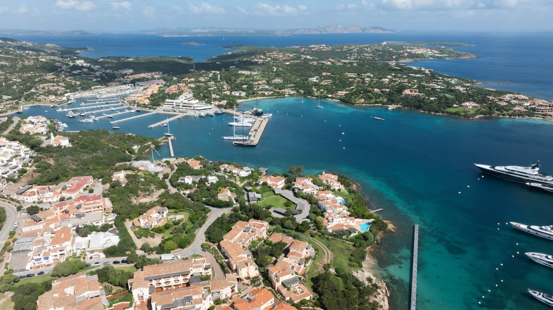 Aerial view of a coastal harbor with boats and waterfront buildings.