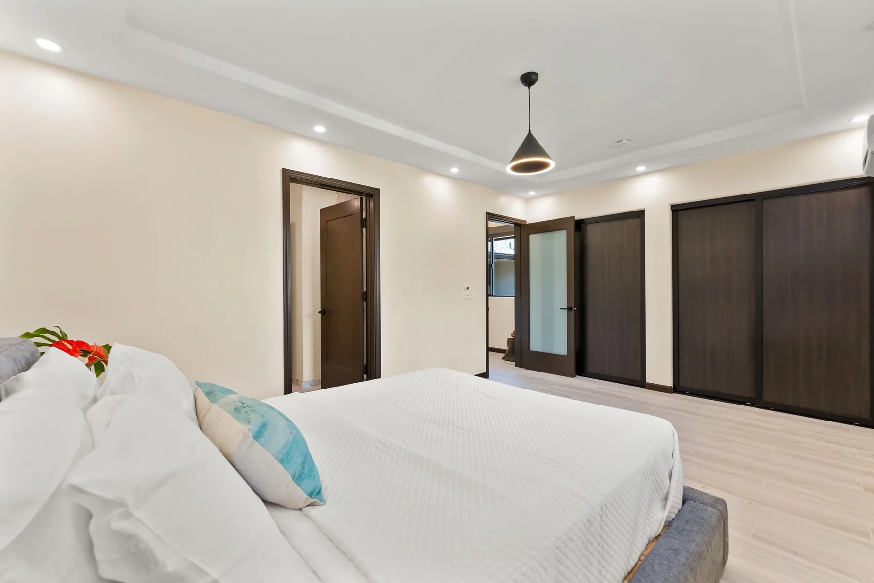 A bedroom with a bed and dark wood doors along the wall.