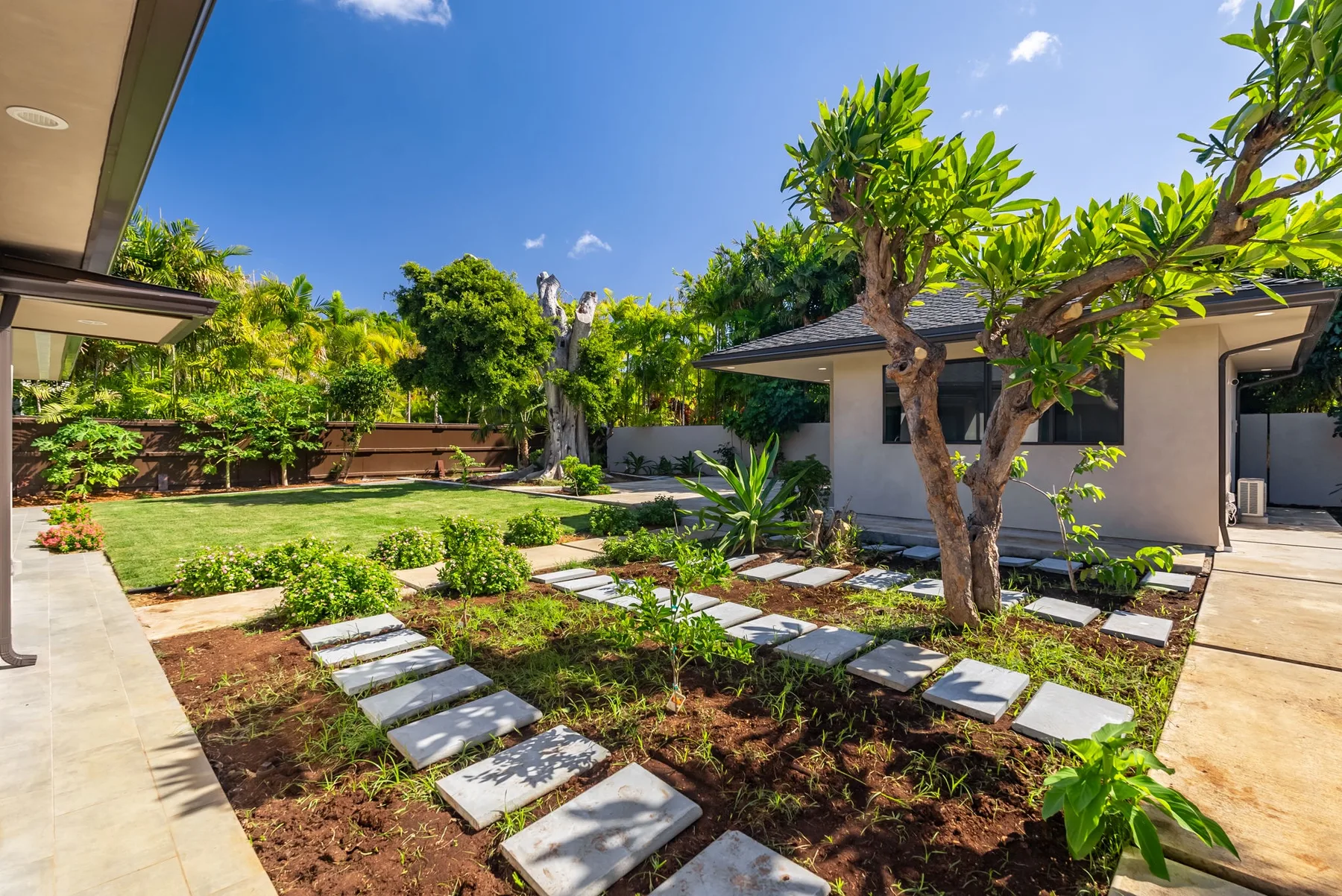 A landscaped outdoor garden with stepping stones and a small building.