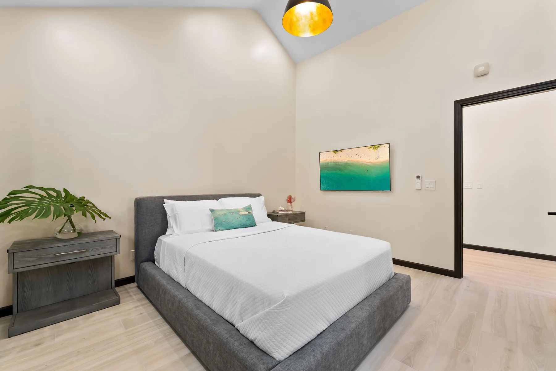 A bedroom with a neatly made bed and a small bedside table.