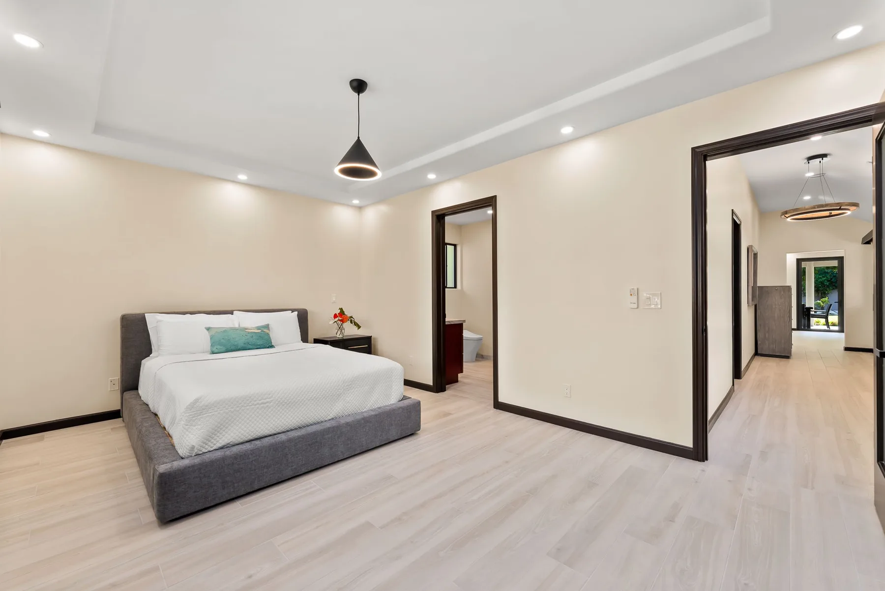 A bedroom with a bed and an open doorway leading to a hallway.