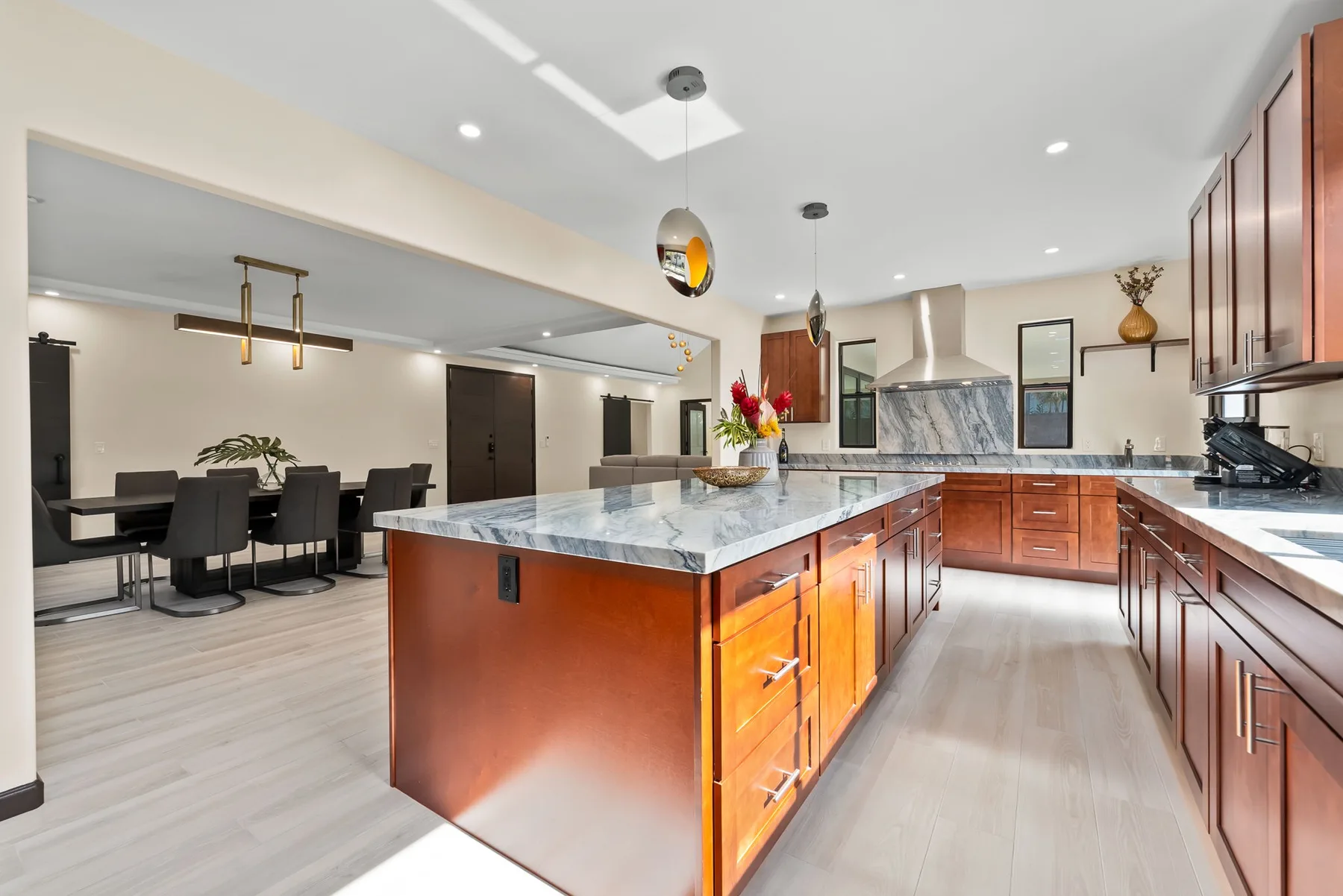 A modern kitchen with a large island and an adjoining dining area.
