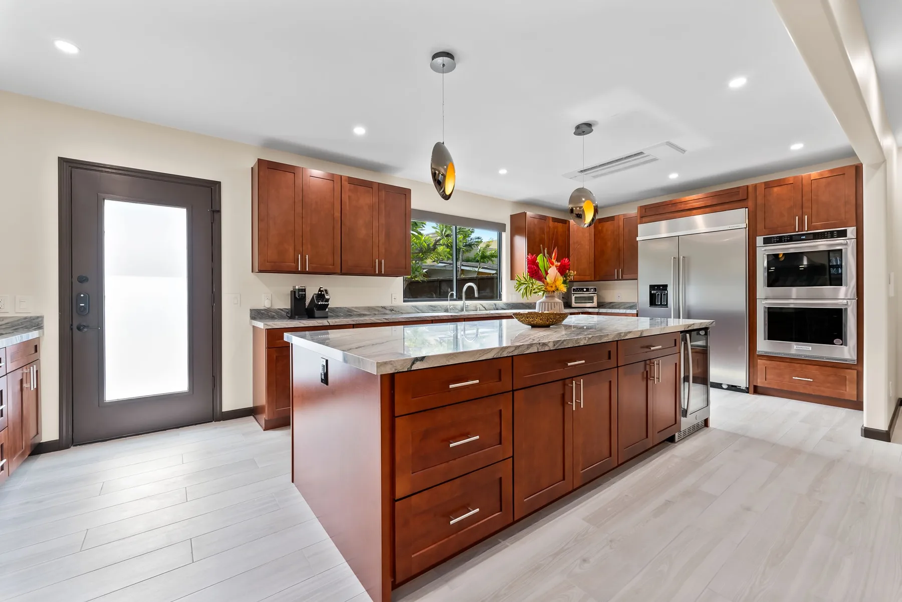 A modern kitchen with dark wood cabinetry and a large central island.