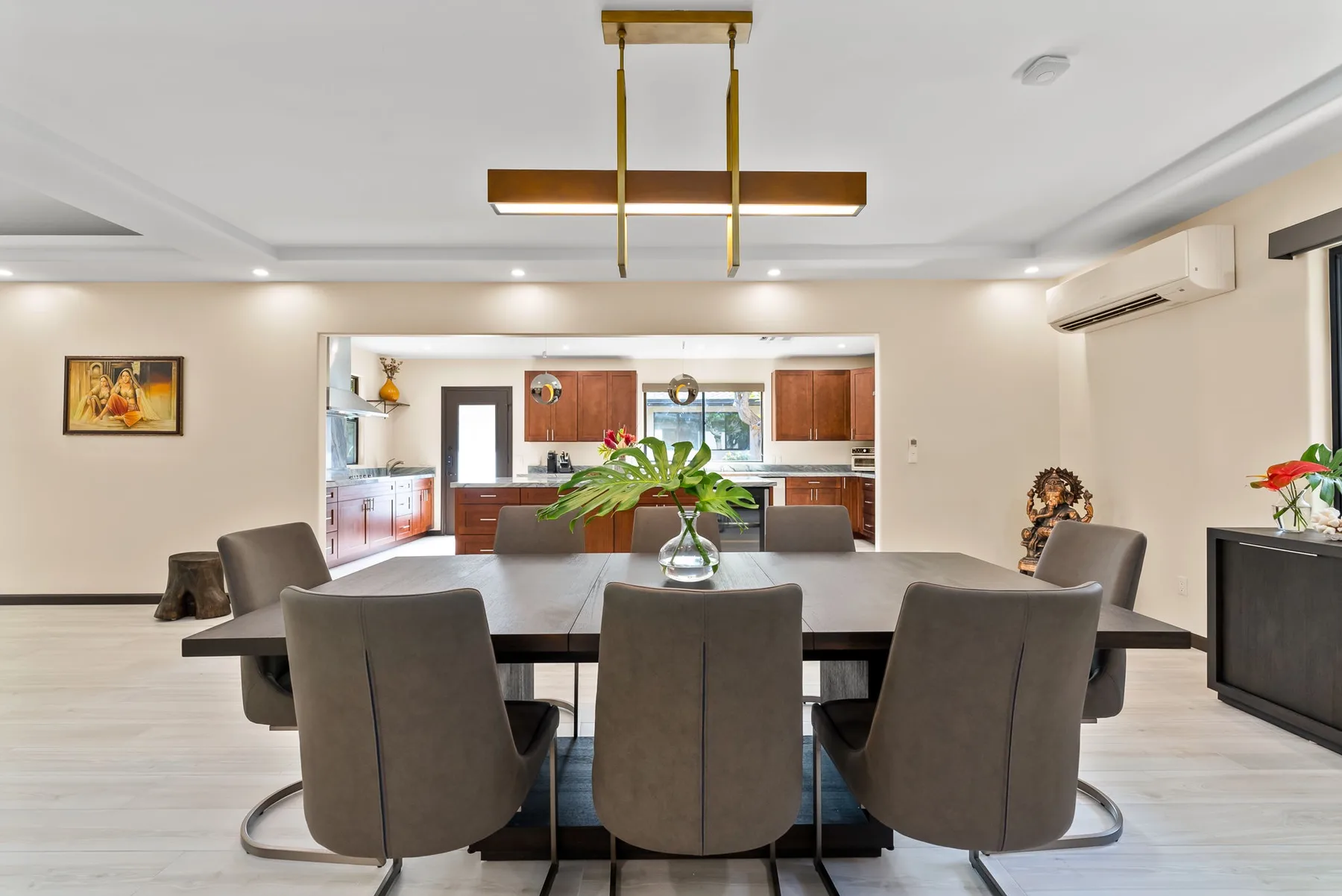 A dining area with a table and chairs, opening onto a kitchen.