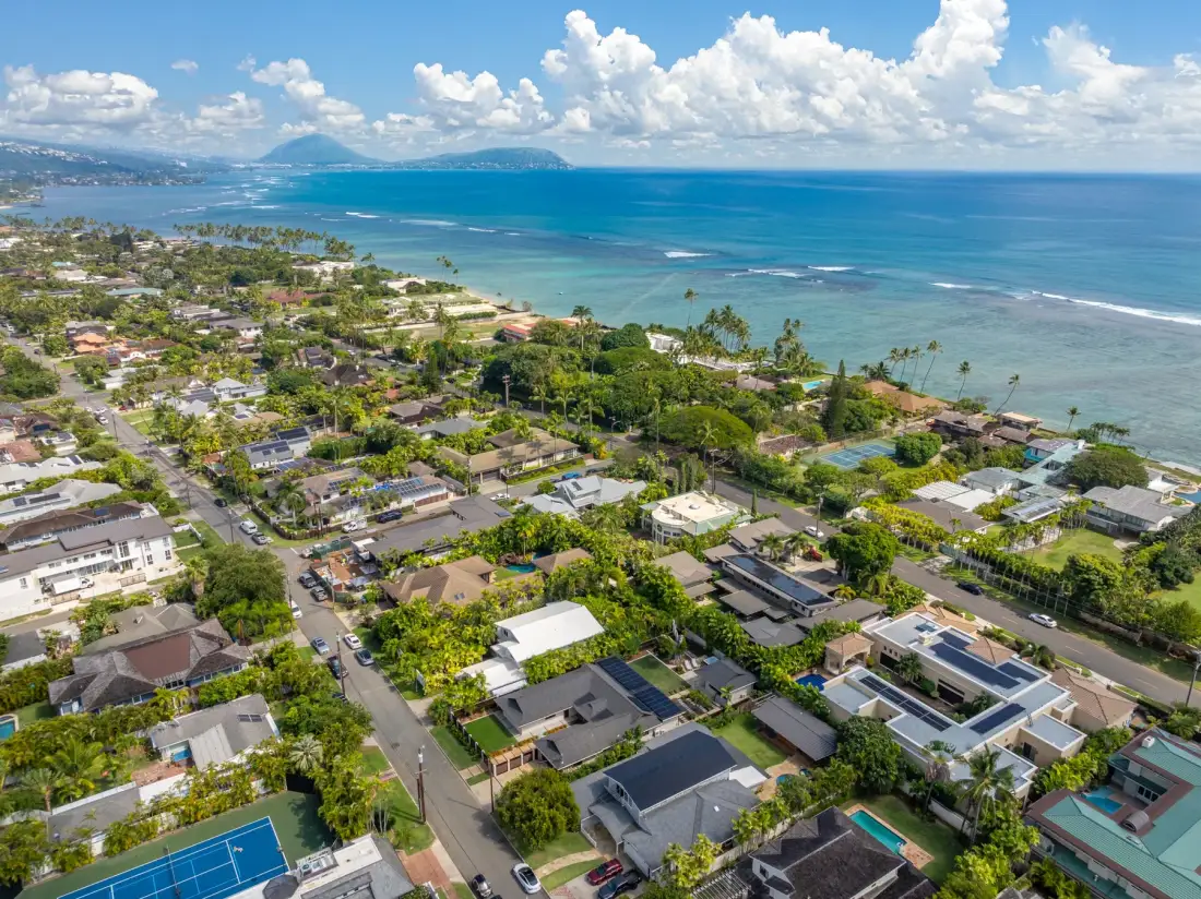 Aerial view of a coastal neighborhood beside a blue ocean.