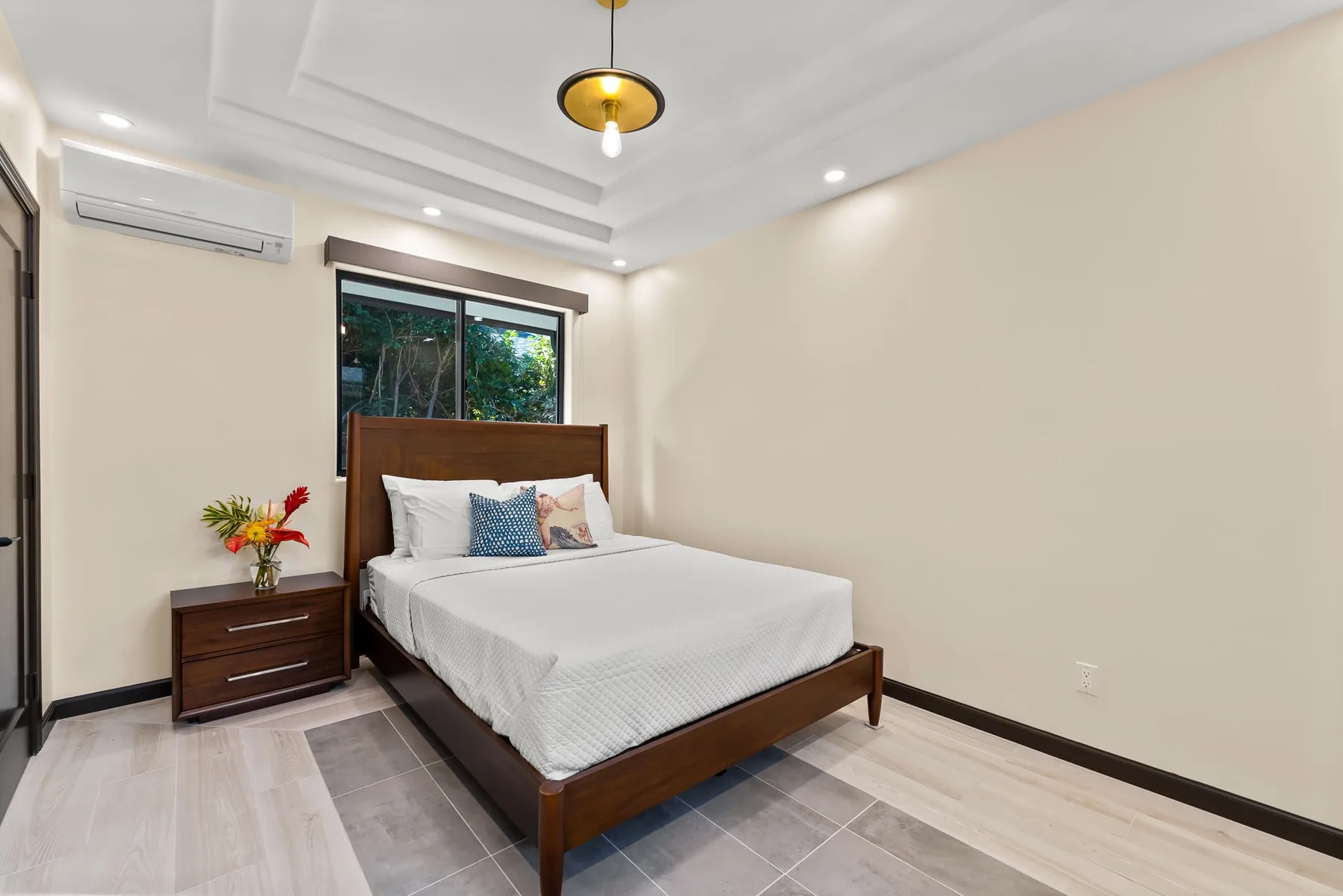 A bedroom with a wooden bed, white bedding, and a window.