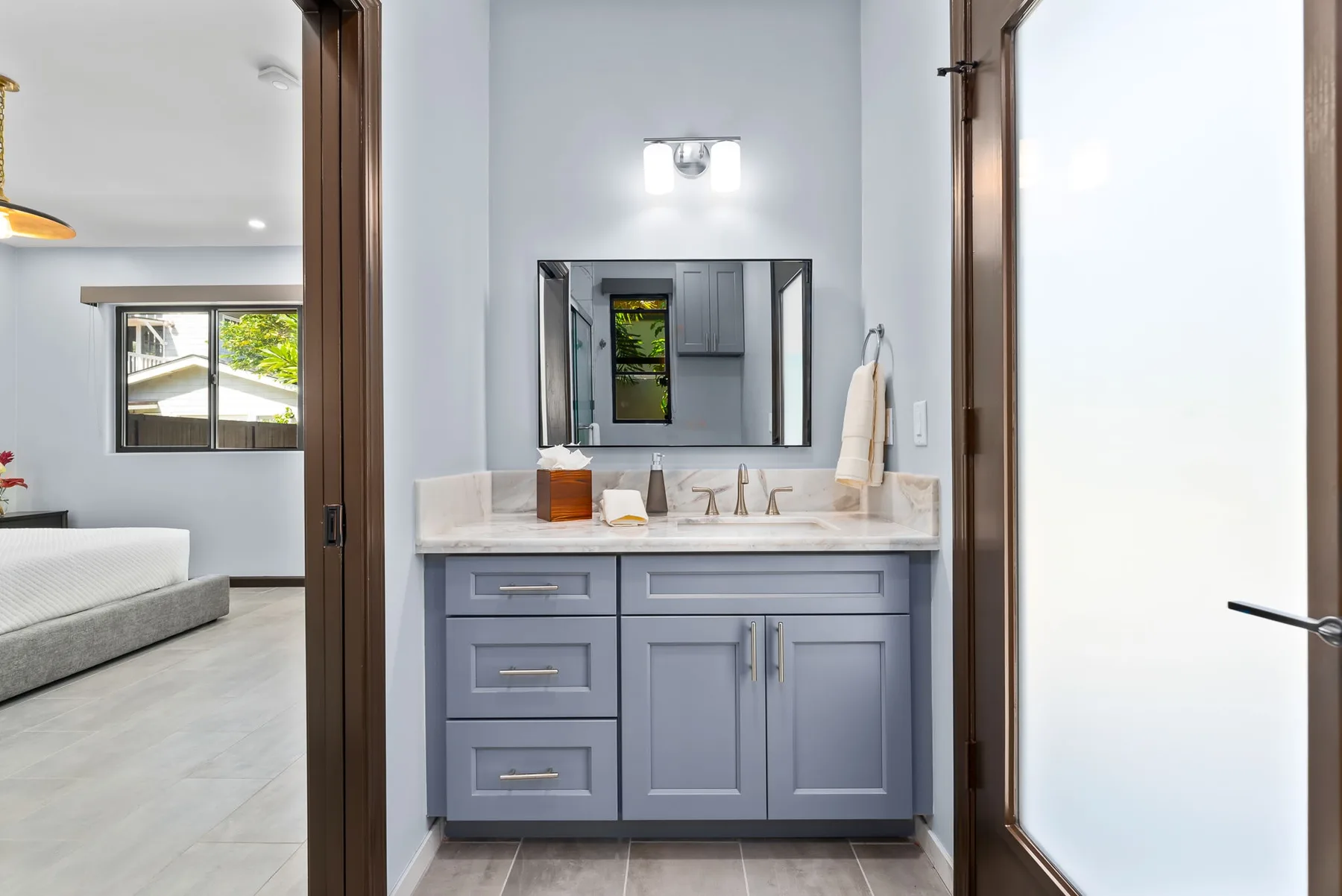 A bathroom vanity with a sink, mirror, and blue-gray cabinets.