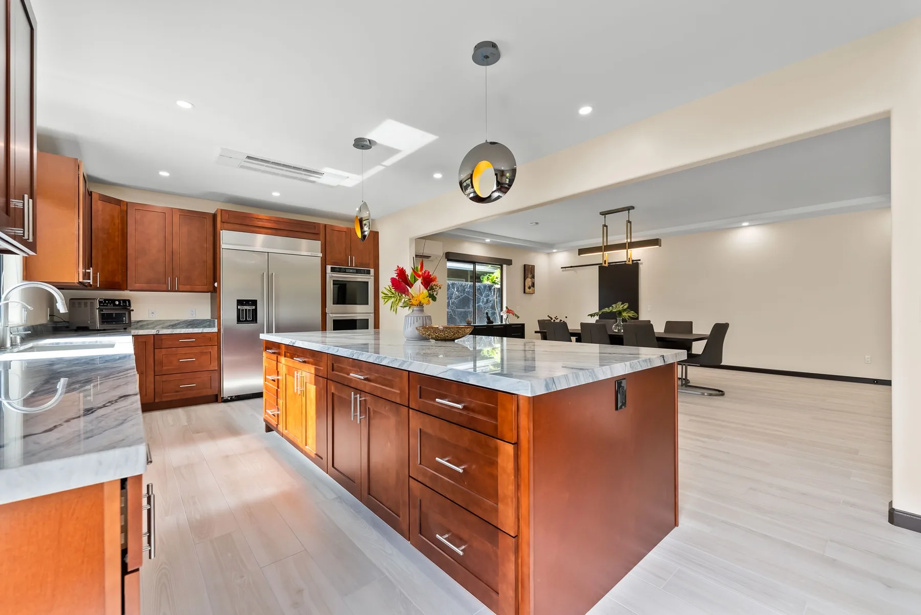 An open kitchen and dining area features a large wooden island and dining table.
