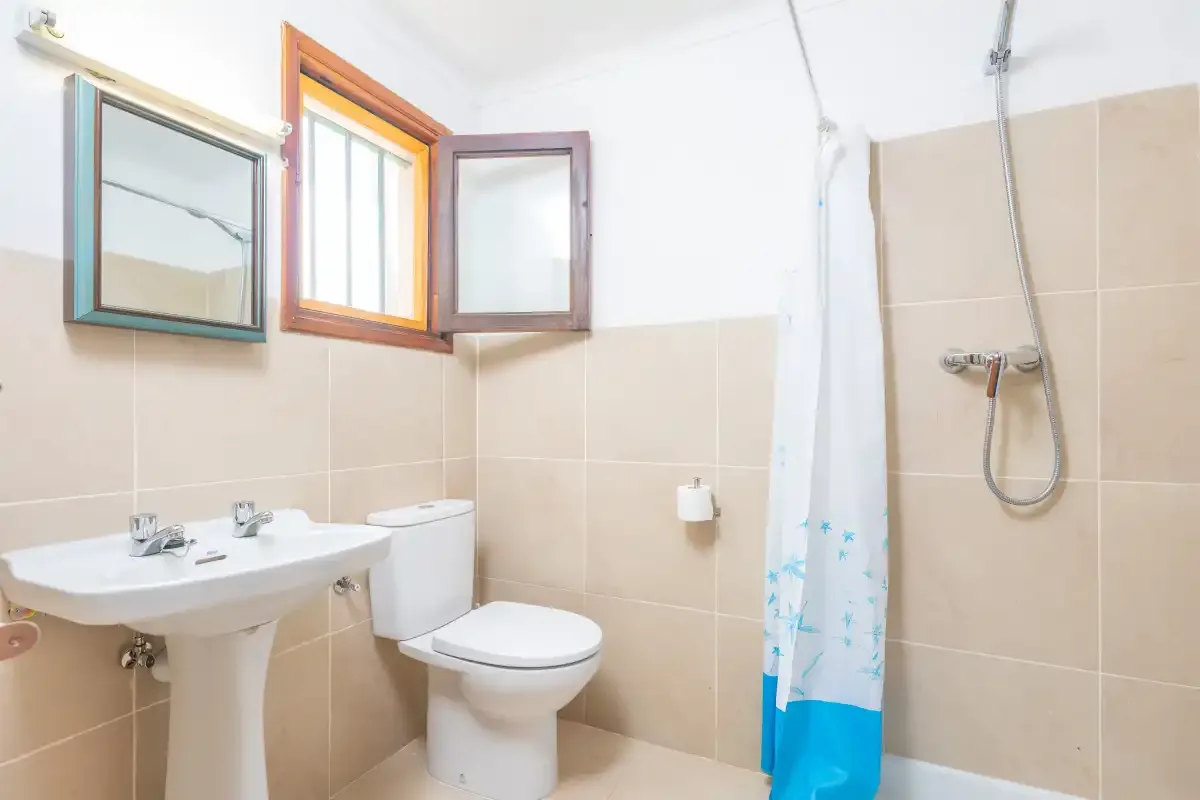 A bathroom with a sink, toilet, and shower curtain.