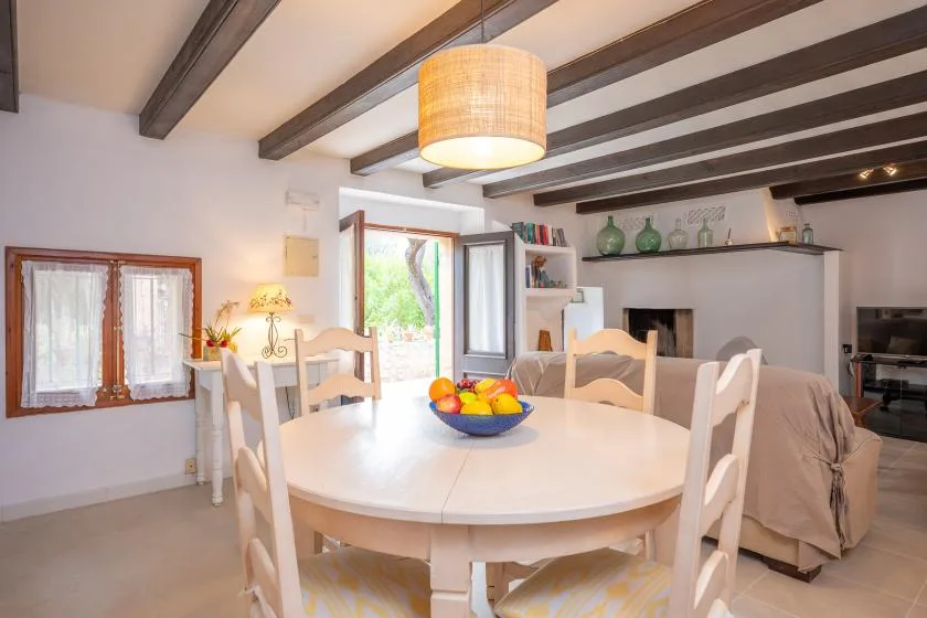 A bright dining area with a round table and an open doorway to the outside.