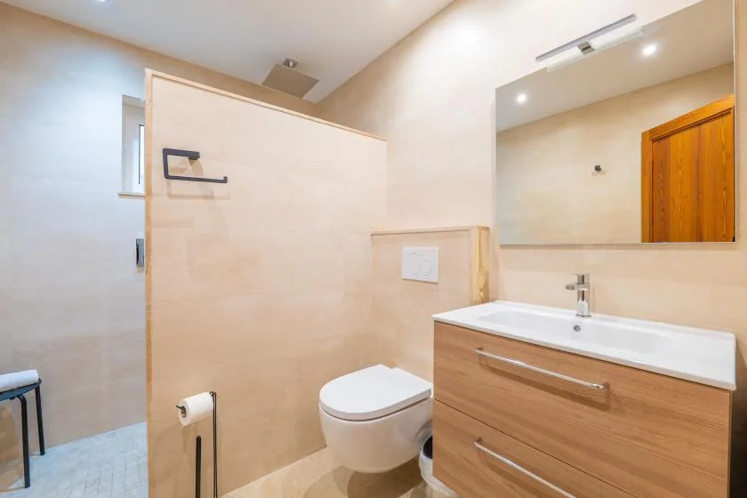 A bright bathroom with a vanity, sink, and toilet.