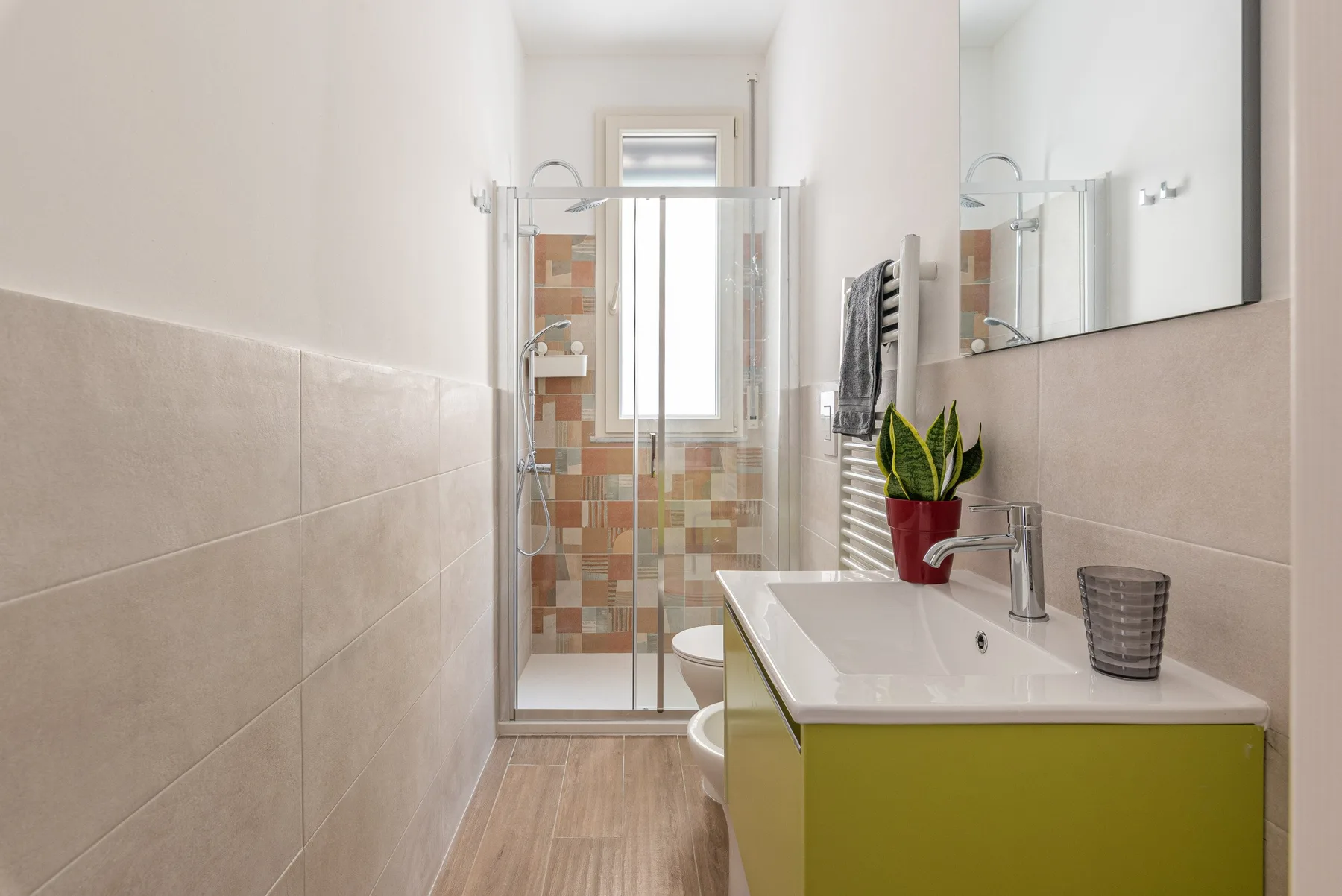 Un baño con ducha de vidrio y lavabo con mueble.