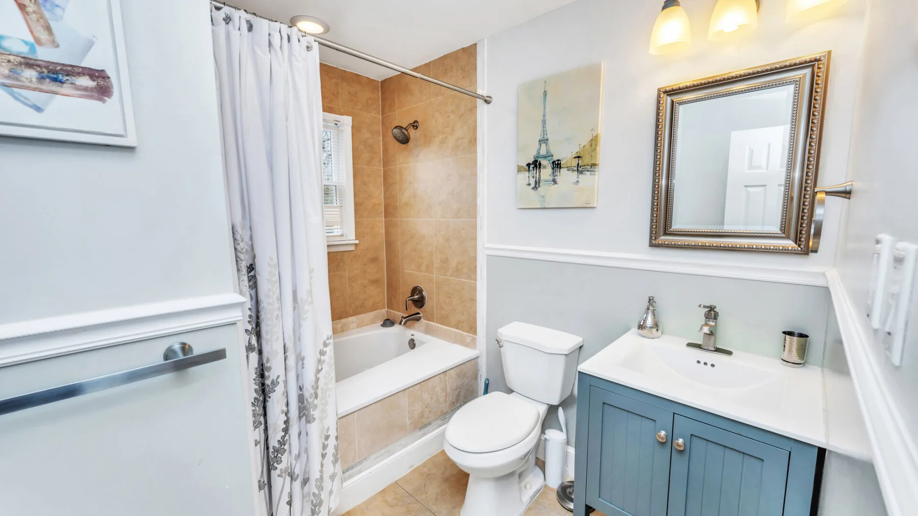 Un baño con bañera, inodoro y tocador azul.
