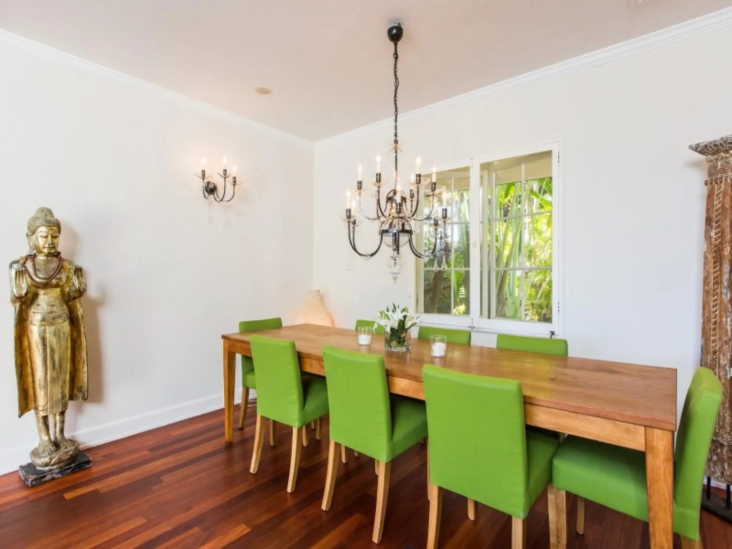 A dining room with a long wooden table and bright green seating.