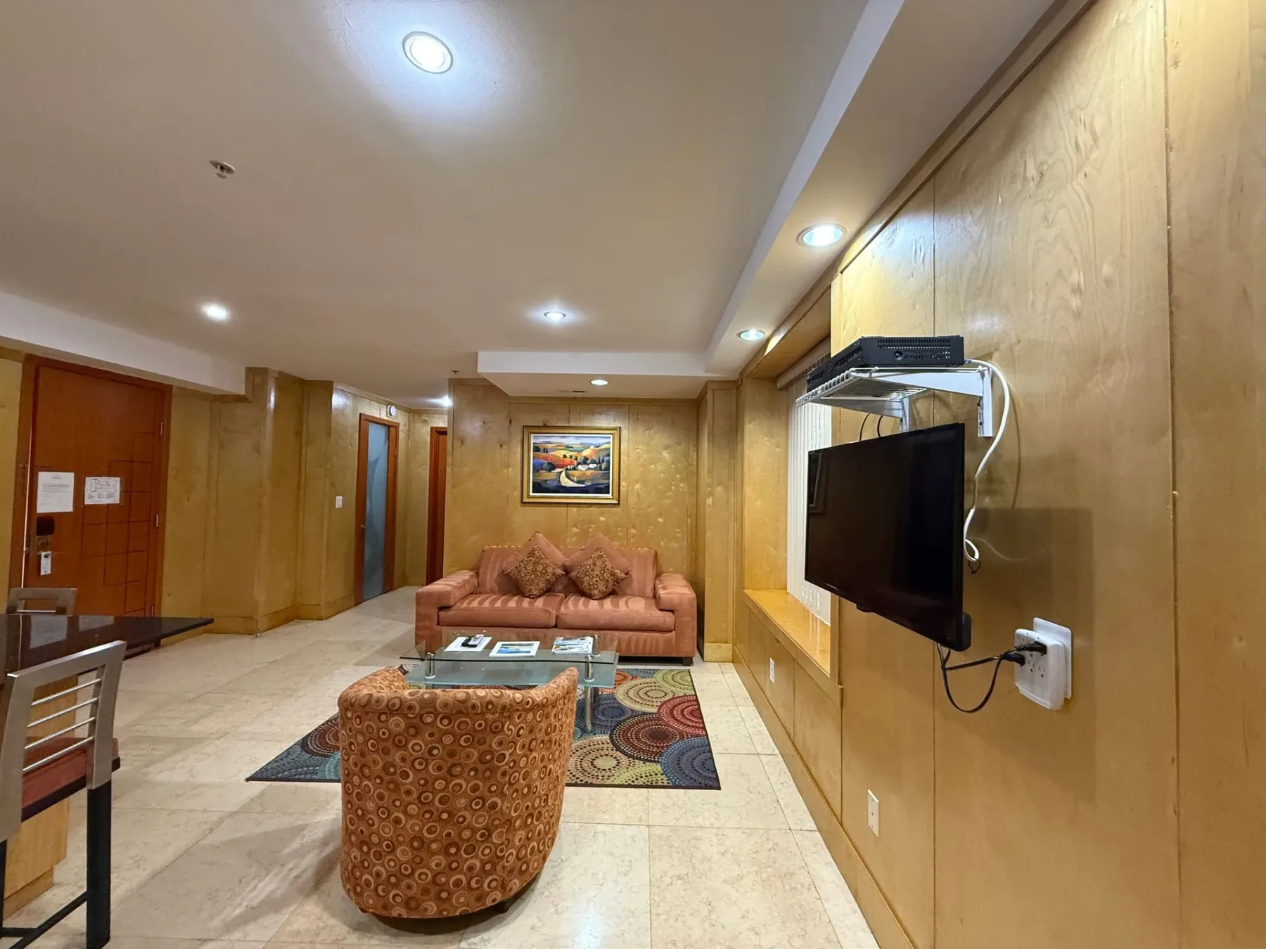 Sala de estar con sofá, silla y televisor.