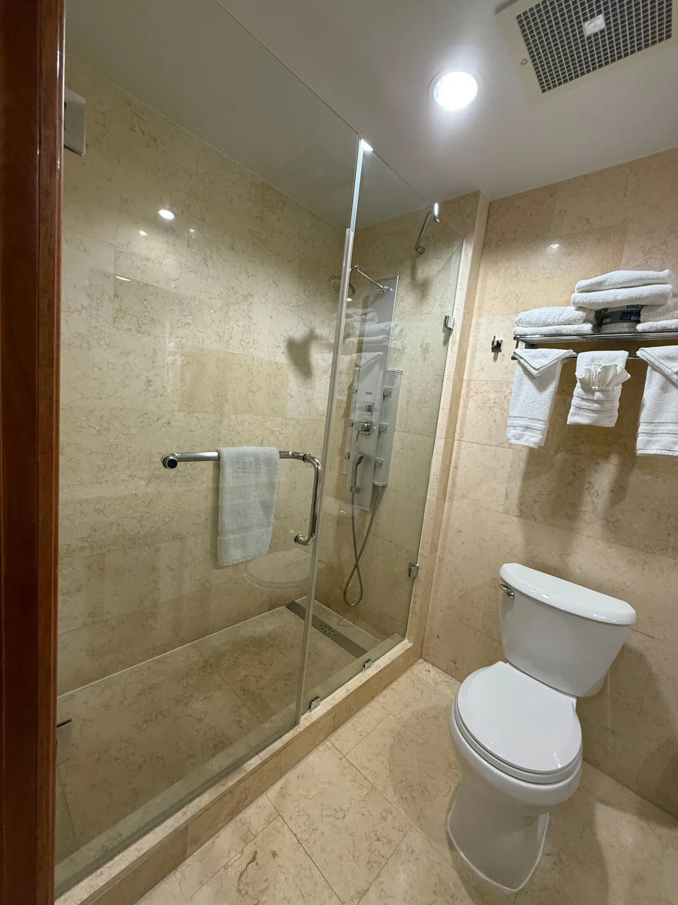 Baño con ducha de vidrio e inodoro.