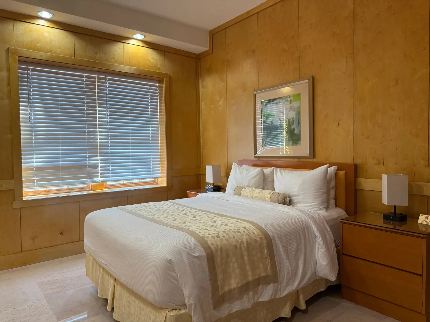 Dormitorio con cama y paredes revestidas de madera.