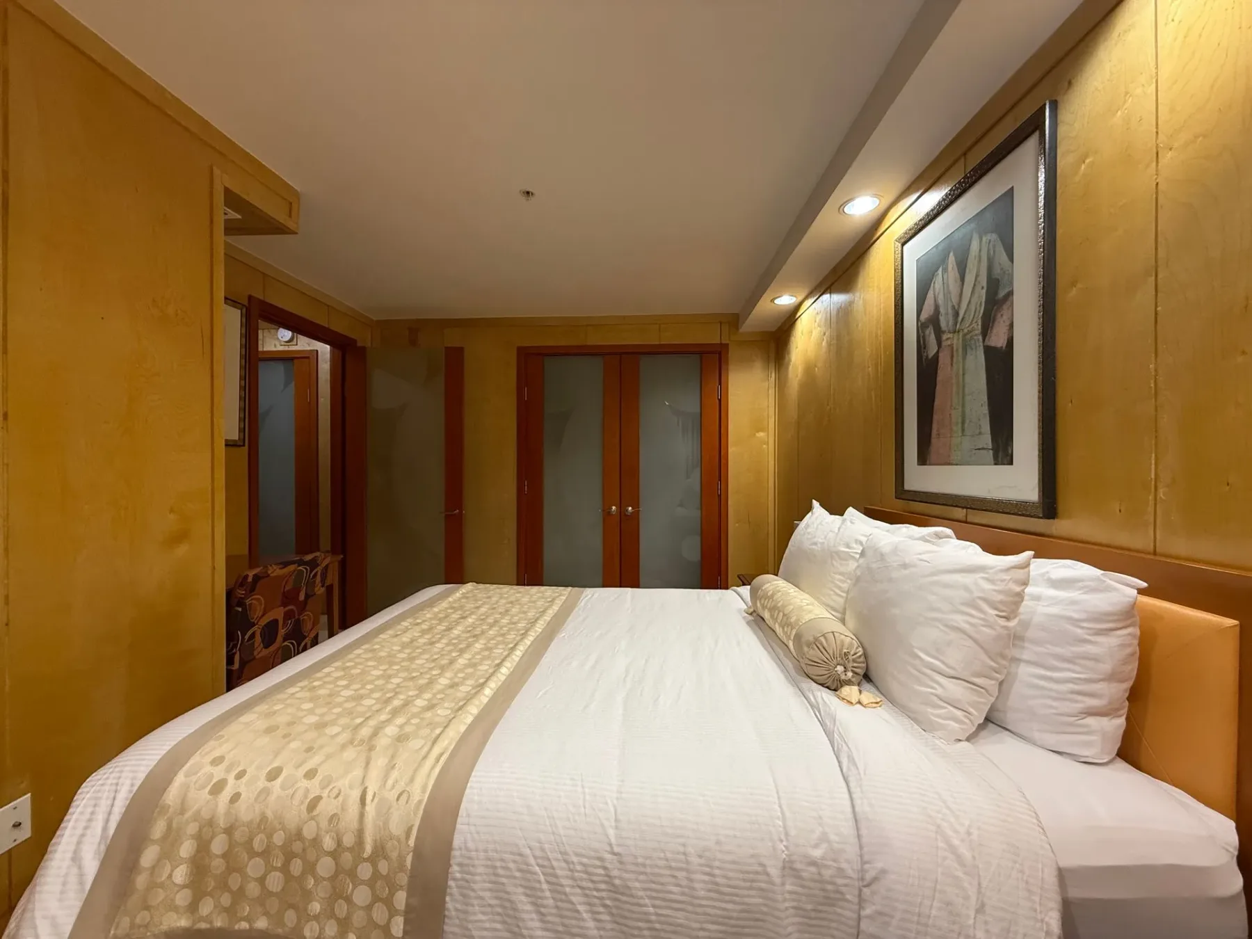 Dormitorio con cama grande y paredes de color dorado.