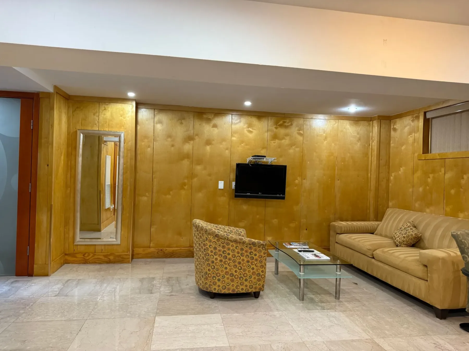 Sala de estar con sofá, silla y televisor.