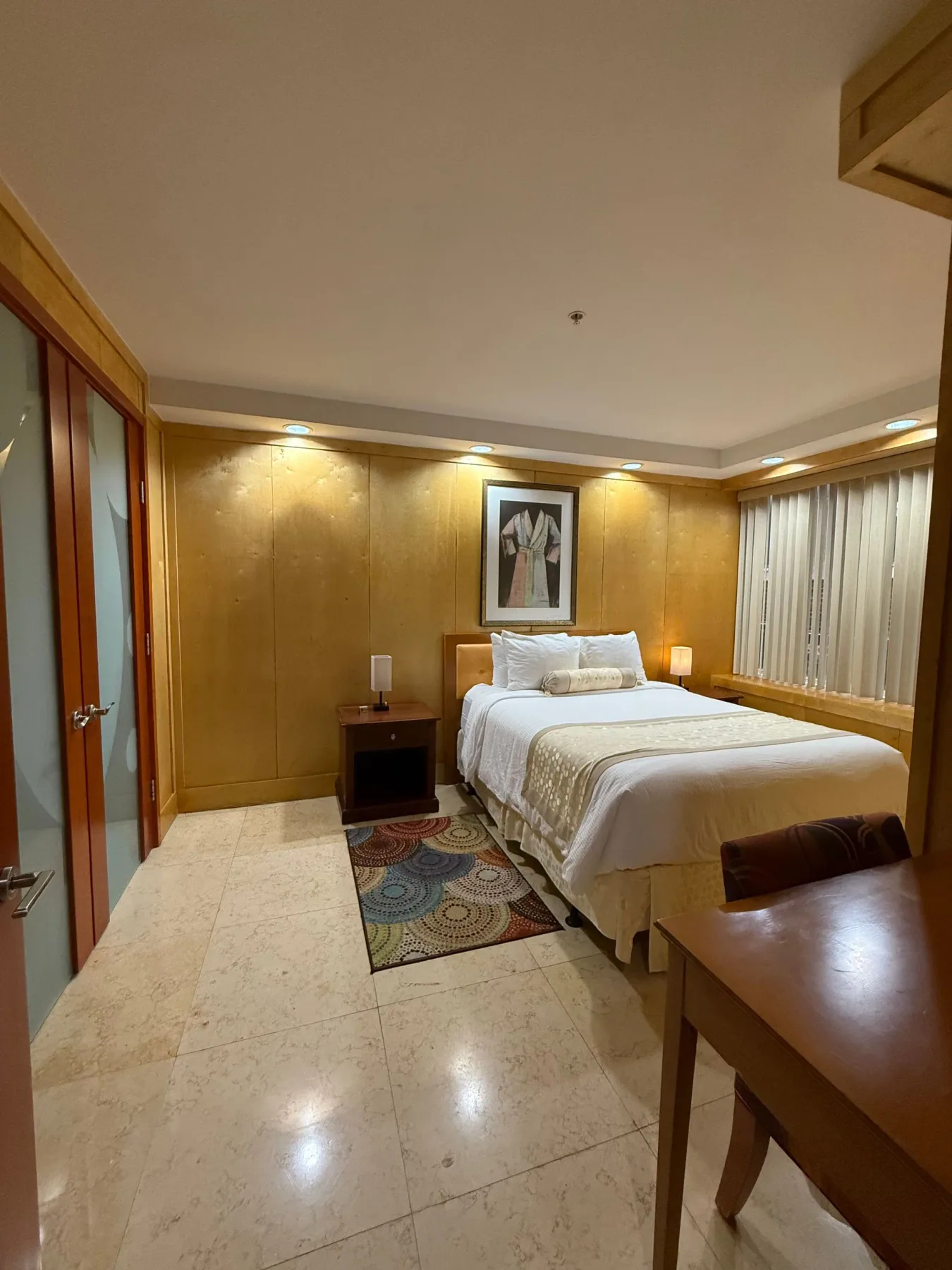 Bedroom with a bed, nightstands and desk.
