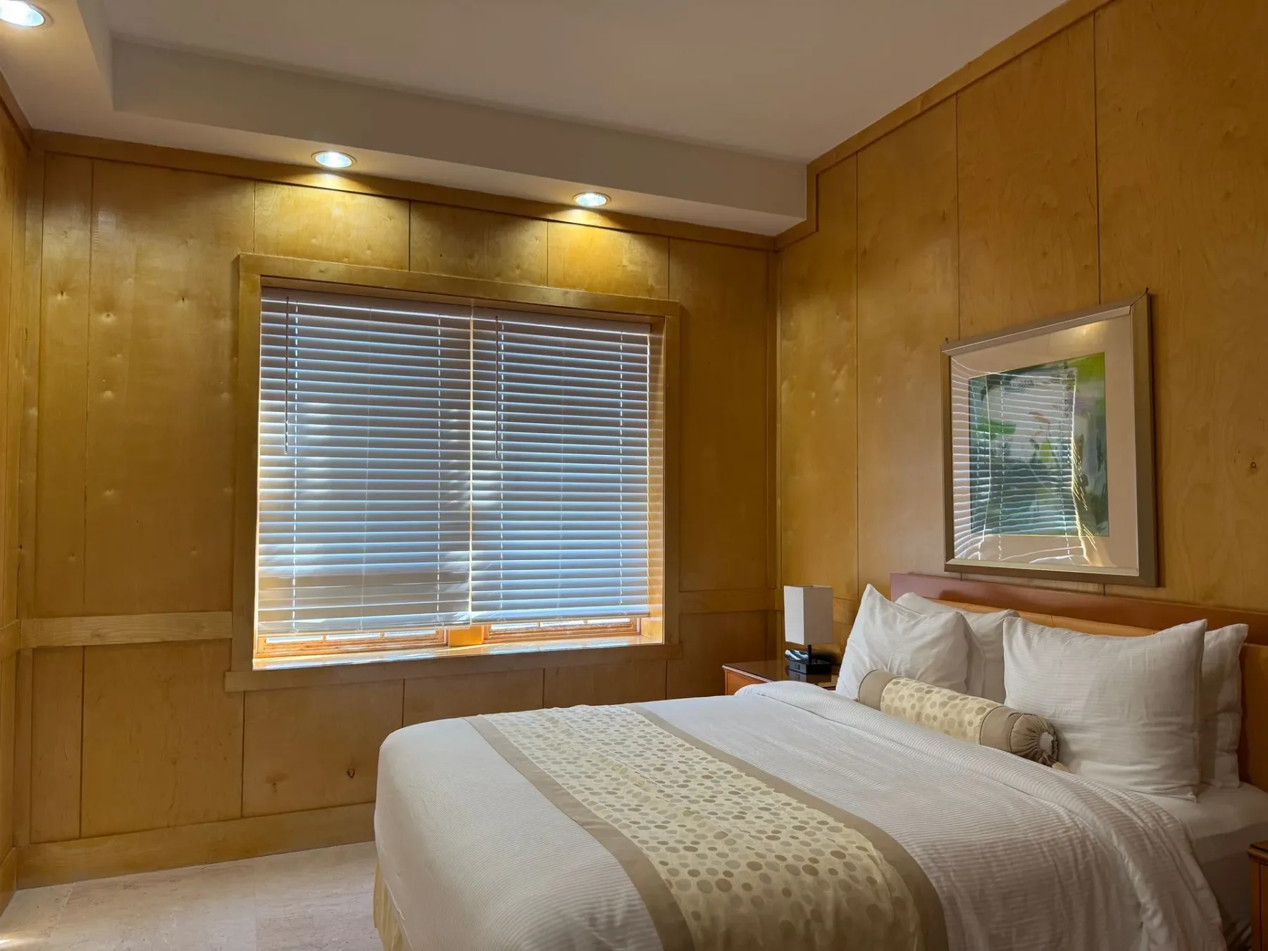 Dormitorio con cama y paredes revestidas de madera.