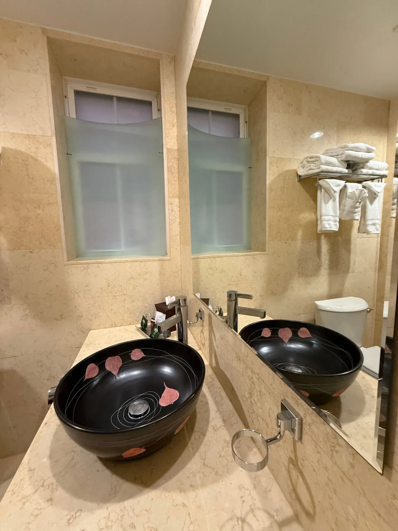 Baño con dos lavabos y ventanas de vidrio esmerilado.
