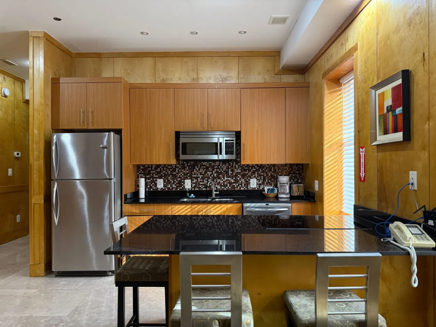 Cocina con electrodomésticos de acero inoxidable y armarios de madera.