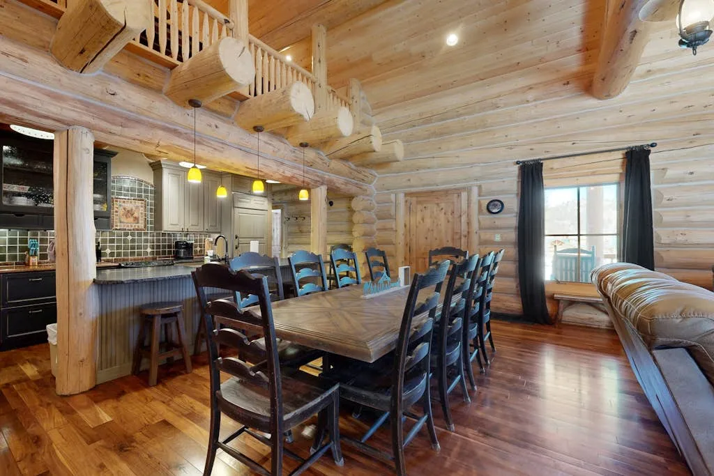 Comedor de madera con una mesa larga y una encimera de cocina.