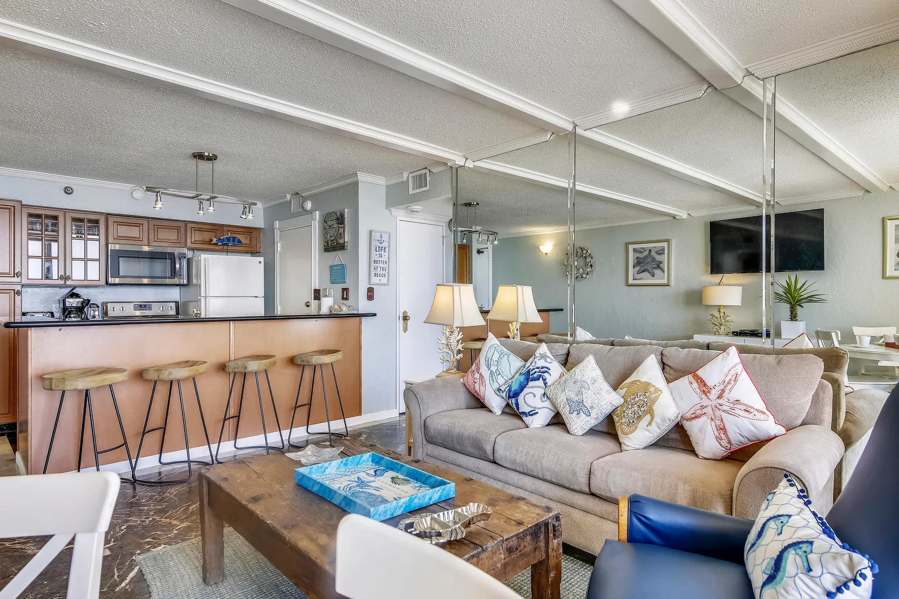An open living room and kitchen with a sofa and breakfast bar.