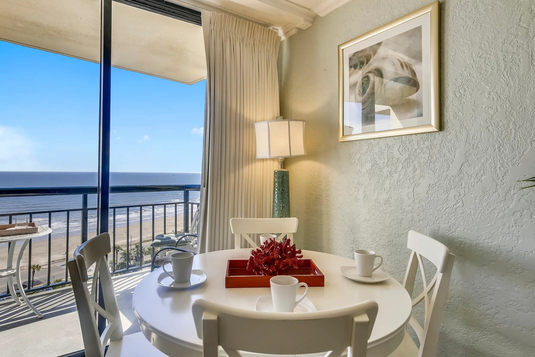 A dining area with a round table set beside a glass balcony door.